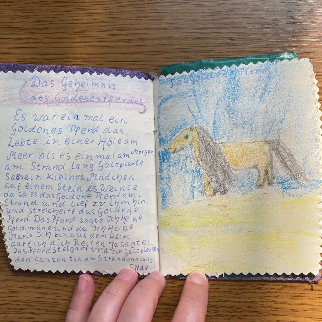 Ein Bild des ersten Kapitels meines ersten Buches, das ich mit etwa 10 Jahren geschrieben habe. Das Kapitel heißt das Geheimnis des goldenen Pferdes. Ein goldenes Pferd und ein Mädchen aus dem Heim lernen sich kennen und werden Freunde. 