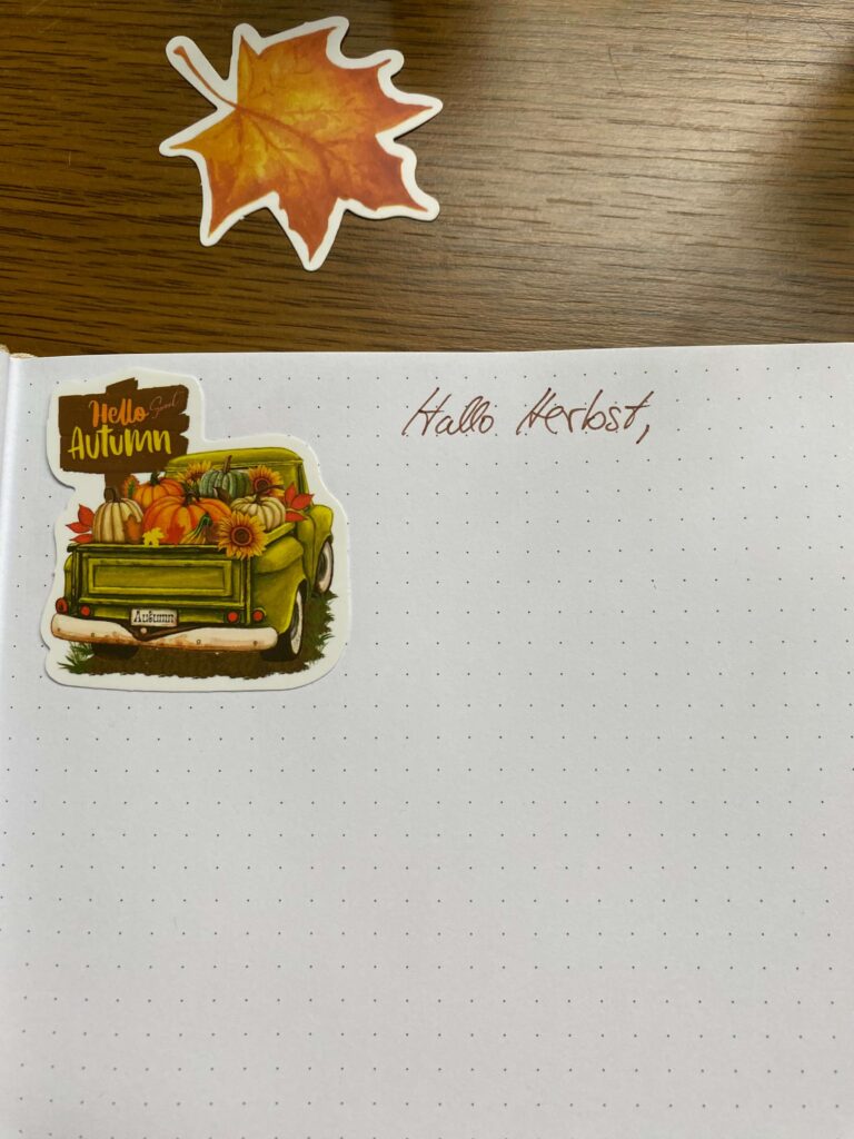 Das Bild zeigt meinen persönlichen Brief an den Herbst bzw. den Anfang des Briefes. Auf einem Sticker steht hello Autumn, daneben habe ich mit braunem Fineliner die Worte Hallo Herbst geschrieben.